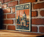 A vintage-style metal sign with the text "AUSTIN TEXAS USA" displayed on a brick wall.
