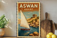 a vintage-style poster of a sailboat on a body of water, with a rocky shore and a temple in the background, all framed by a decorative border.