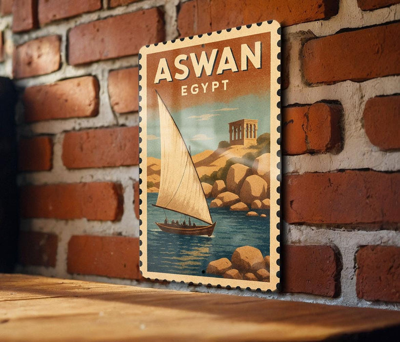 a vintage-style poster of a sailboat on a body of water, with the text "ASWAN EGYPT" prominently displayed.