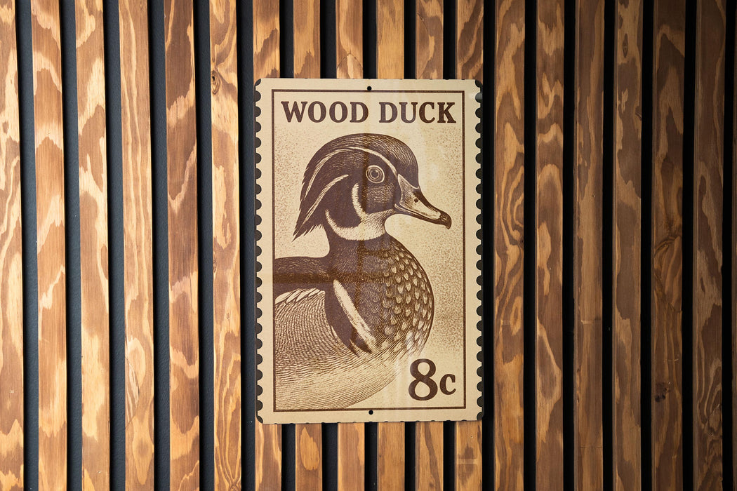 A wooden wall with a postage stamp featuring a wood duck.