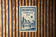 A metal sign with the text "Memphis, Tennessee, USA" and an illustration of a bridge and city skyline.