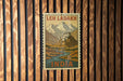 A vintage-style postage stamp from India featuring a mountain landscape with a small village or town in the background.