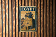 A metal sign with the word "EGYPT" on it, featuring an illustration of the Great Sphinx of Giza.
