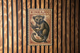 A wooden wall with a framed image of a kangaroo, which appears to be a postage stamp or a decorative piece.