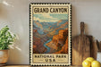 A vintage-style metal sign for the Grand Canyon National Park, featuring a colorful illustration of the iconic canyon landscape.