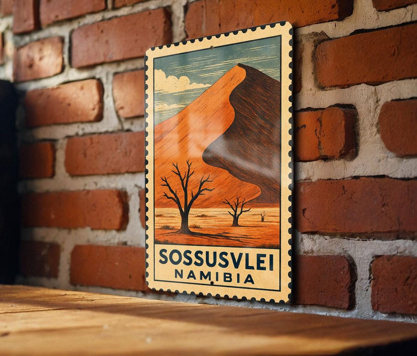A vintage postage stamp depicting a desert landscape with a mountain in the background, hanging on a brick wall.