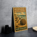 A vintage-style metal sign for the Moeraki Boulders in New Zealand, featuring a beach scene with large boulders and a soccer ball.