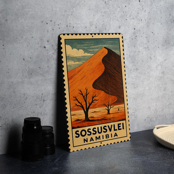 A vintage-style metal stamp depicting a desert landscape with a mountain in the background, along with the text "SOSSUSVLEI NAMIBIA".