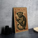 A wooden postcard featuring a tarsier, a small primate, is displayed on a table next to some black camera lenses.