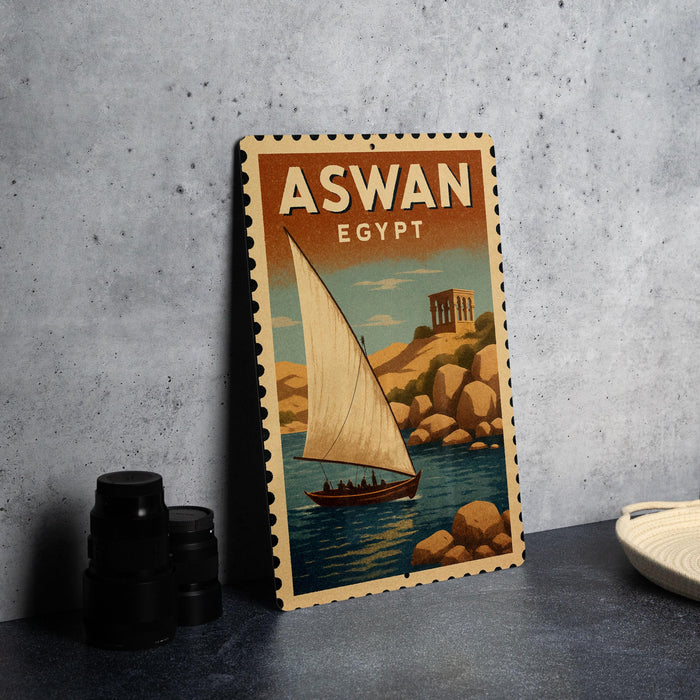 A vintage-style poster of a sailboat on a body of water, with the text "ASWAN EGYPT" prominently displayed.