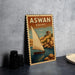 A vintage-style poster of a sailboat on a body of water, with the text "ASWAN EGYPT" prominently displayed.