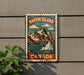 A vintage-style metal sign with a mountain landscape and a small island, mounted on a wall.