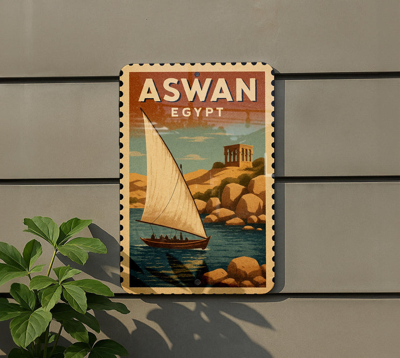 A vintage-style poster of a sailboat on a body of water, with the text "ASWAN EGYPT" prominently displayed.