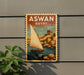 A vintage-style poster of a sailboat on a body of water, with the text "ASWAN EGYPT" prominently displayed.