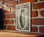 a black and white illustration of a sea cucumber on a brick wall.
