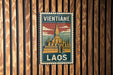 A vintage postage stamp featuring a temple in Laos, with the text "Vientiane LAOS" prominently displayed.