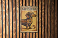 A metal stamp featuring a dachshund dog, with the text "DACHSHUND" and the denomination "5c" printed on it.