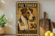 a framed poster of a fox terrier dog, with the number "30" printed on it. The poster is displayed on a shelf next to a wooden cutting board and some lemons.