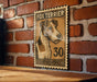 a wooden table with a framed poster of a fox terrier dog on it, mounted on a brick wall.