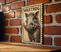 A wooden table with a wooden border, and a framed illustration of a warthog on the wall.