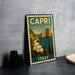 A vintage-style metal sign depicting the picturesque town of Capri, Italy, with its iconic rock formations and the sea in the background.