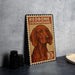 A metal sign featuring a redbone coonhound dog, with a stamp-like border and text indicating the dog's breed.