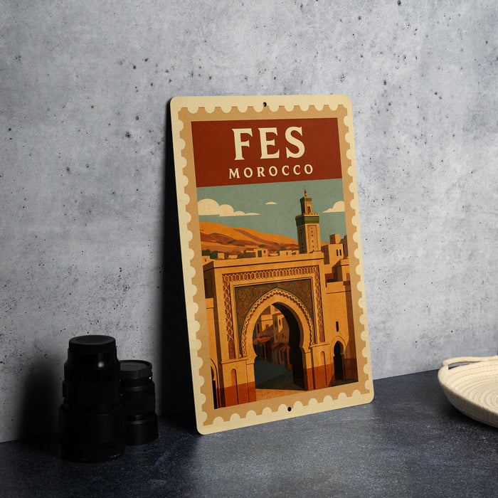 a metal sign with a vintage-style illustration of a Moroccan archway, placed on a table next to some black camera lenses.