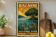 A vintage-style metal sign for Biscayne National Park, featuring illustrations of a tropical island, sea turtle, and fish, is displayed on a shelf next to a wooden cutting board and a potted plant.