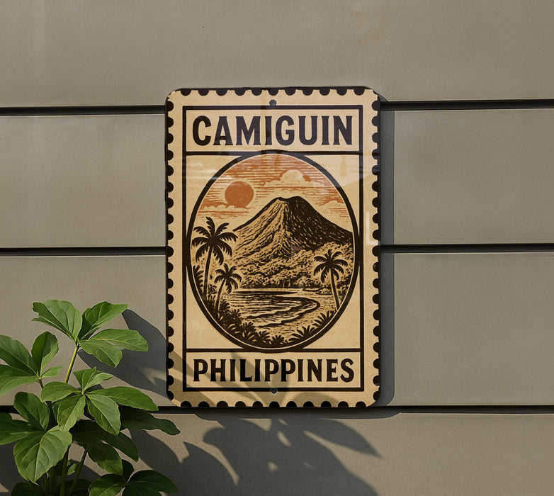 a sign that reads "Camiguin Philippines" with a tropical mountain landscape and palm trees depicted on it.