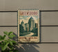 A metal sign with a vintage-style illustration of Greensboro, North Carolina, featuring a cityscape with tall buildings and a winding road.