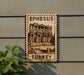 A wooden sign with the text "EPHESUS TURKEY" and an illustration of an ancient building, likely the Library of Celsus in Ephesus, Turkey.