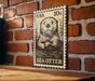 A wooden surface with a framed image of a sea otter on it, mounted on a brick wall.