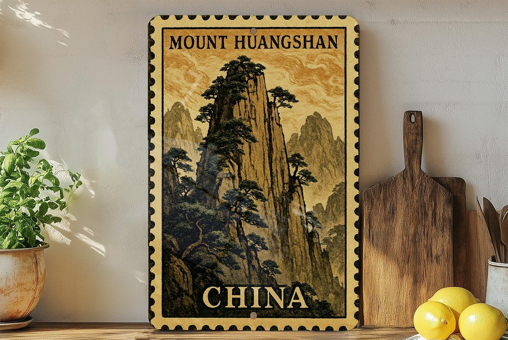 a framed poster of a mountainous landscape with the text "Mount Huangshan" and "CHINA" printed on it, placed on a shelf next to a wooden cutting board and some potted plants.