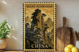 a framed poster of a mountainous landscape with the text "Mount Huangshan" and "CHINA" printed on it, placed on a shelf next to a wooden cutting board and some potted plants.