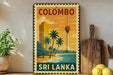 A vintage-style stamp depicting a tropical beach scene with palm trees, a tower, and a body of water, with the text "COLOMBO SRI LANKA" printed on it.