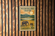 A vintage postage stamp from Tanzania, featuring an illustration of elephants in a grassy field with mountains in the background.