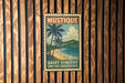 A vintage-style poster of Saint Vincent and the Grenadines, featuring palm trees and a beach scene, is displayed on a wooden wall.
