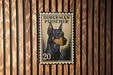 A metal stamp featuring a Doberman Pinscher dog, with the number 20 printed below the dog's head.
