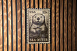 A black and white postage stamp featuring an illustration of a sea otter.