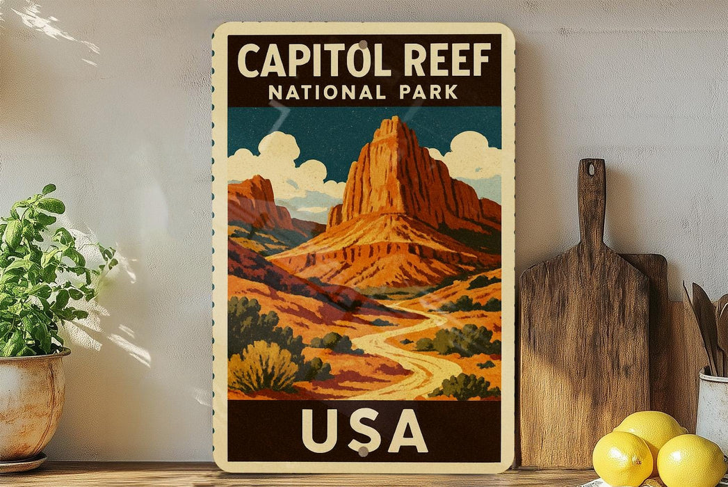 A vintage-style poster of Capitol Reef National Park in the United States, featuring a mountain landscape with a winding road and a cloudy sky.