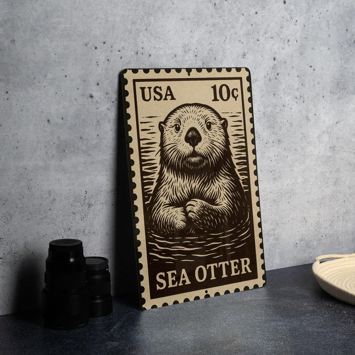 A metal stamp featuring a sea otter, with the text "USA 10c" printed on it.