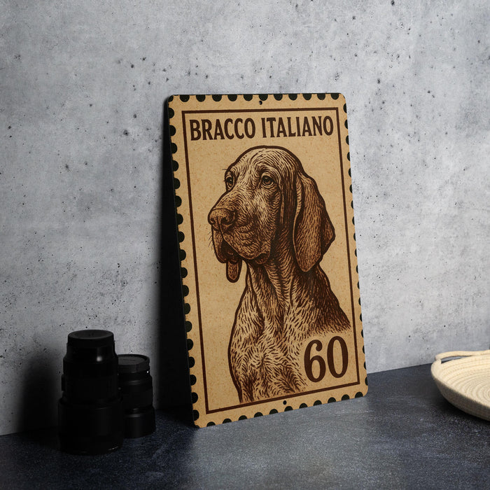 A wooden stamp with a dog illustration and the number 60 on it, placed on a gray surface next to some black camera lenses.