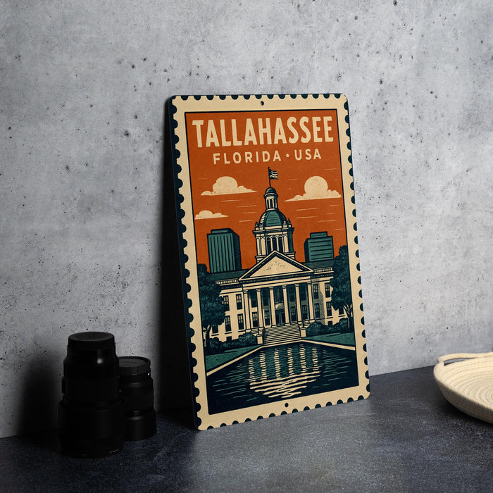 A metal sign with the text "Tallahassee, Florida, USA" and an illustration of the Tallahassee State Capitol building.