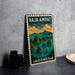 A vintage-style metal sign with the text "RAJA AMPAT INDONESIA" and an illustration of islands and a sunset over the ocean.