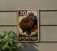 A vintage-style stamp featuring a stonefish is displayed on a wall, with a plant to the left.