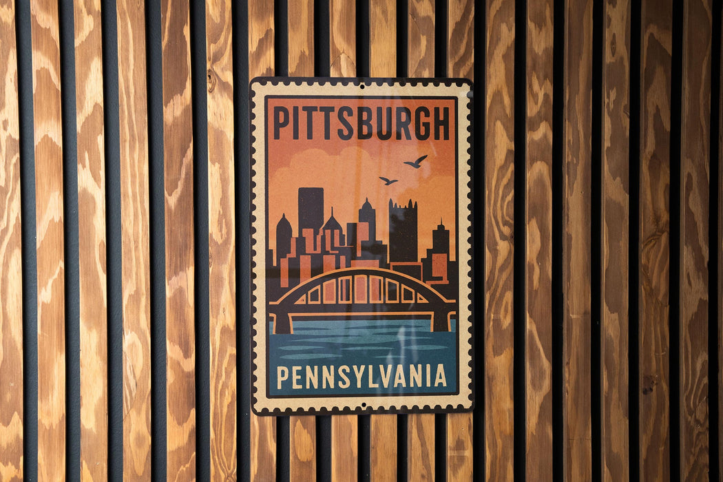 A vintage-style poster of the Pittsburgh skyline, featuring a bridge and the city's name, is displayed on a wooden wall.