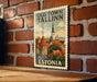 A vintage-style poster of Tallinn, the capital city of Estonia, displayed on a brick wall.