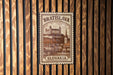 A metal sign with the text "BRATISLAVA SLOVAKIA" and an illustration of a castle or palace, mounted on a wooden wall.