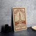 A metal sign with the text "BATON ROUGE LOUISIANA USA" and an illustration of the Louisiana State Capitol building.