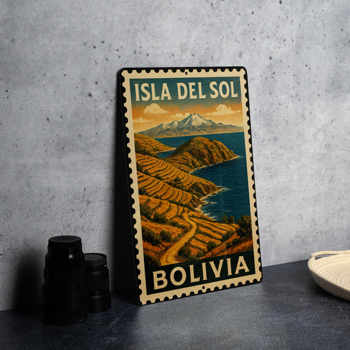 A vintage-style metal sign with the text "ISLA DEL SOL BOLivia" printed on it, depicting a mountainous landscape with a river or ocean in the background.